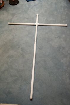 a cross laying on the floor next to some shoes and other things in front of it