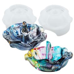 two glass bowls sitting next to each other on top of a white surface with one bowl in the middle