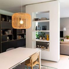 a dining room table and chairs in front of a bookshelf