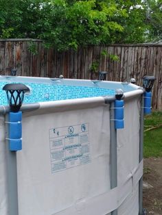 an above ground swimming pool with blue tiles on the sides and lights at the top