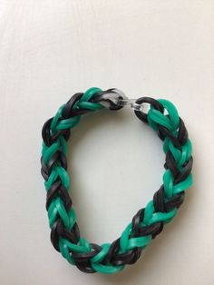 a green and black braid bracelet on a white surface