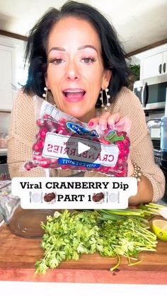 a woman holding up a bag of cranberry dip in front of her face