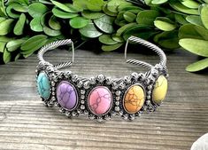 Be sure to check our shop announcements for any current sales or coupon codes!  All discount information will be posted there.  Western fashion oval cuff bracelets! Colors- Multi color pastel stones One size fits most ~ Approx. 2.75" across, 2.5" deep (front to back)  Approx. 1" width Burnished silver metal  Distressed details Stones will vary in design.  Each is has different characteristics. Nickel and lead compliant FINAL SALE- please check dimensions and details before purchasing, just to en Silver Bohemian Cuff Bracelet For Spring, Bracelets Colors, Statement Cuff Bracelet, Color Pastel, Loose Stones, Crown Jewels, Oval Stone, Work For You, Stone Bracelet