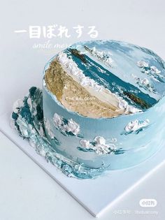 there is a blue cake with white frosting on the top and gold foil in the middle