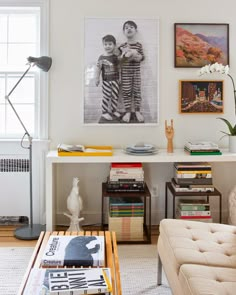 a living room filled with furniture and pictures on the wall