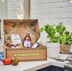 a box filled with food sitting on top of a counter next to potted plants