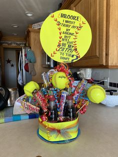 a yellow bucket filled with baseballs and drinks sitting on top of a kitchen counter