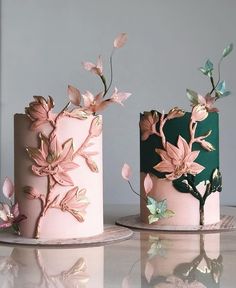 two cakes decorated with pink and green frosting on top of a white table next to each other