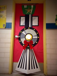 a door decorated like a train with a light on it's head and red ribbon