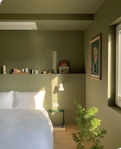 a bed sitting in a bedroom next to a window with a potted plant on top of it