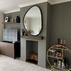 a living room filled with furniture and a large round mirror on the wall above a fireplace