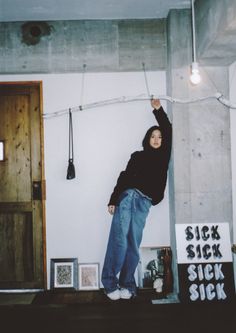 a woman standing on top of a wooden shelf next to a sign that says sick sick sick sick sick