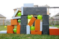 an outdoor sculpture made out of orange and green apples