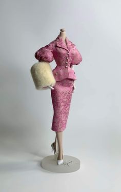 a mannequin wearing a pink dress and hat