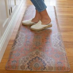 a woman standing on top of a rug with her feet in the air and wearing slippers