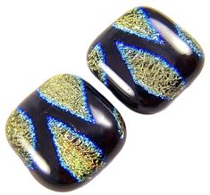 two black and gold glass beads with blue, yellow and green designs on them sitting next to each other