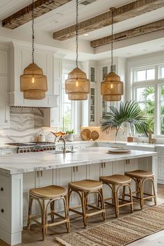 a kitchen island with stools and lights hanging from it's ceiling in front of windows