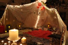 a bed with some lights on it and candles in front of the bedspread