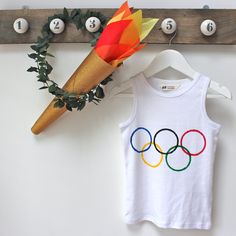 an olympic t - shirt hanging on a coat rack next to a flower and ice cream cone