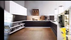 a kitchen with white cabinets and brown flooring next to a book shelf filled with books