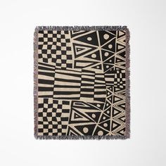 a black and white rug with an abstract design on the front, hanging from a wall