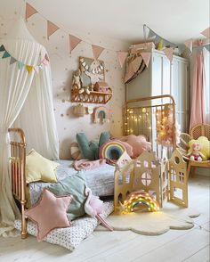 a child's bedroom decorated in pastel colors and gold, with lots of toys on the floor