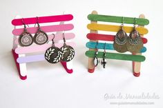 two pairs of earrings are sitting on a bench