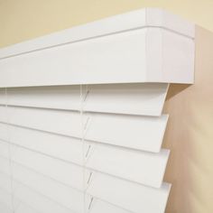 a close up of a window with white blinds