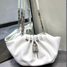 GIVENCHY Kenny Bag small size This bag was specially designed by Givenchy for Kendall Jenner to attend the Met Gala, so it was named Kenny Bag. The shape is a bit like a cloud bag ☁️ with the added logo G-shaped chain ⛓️ and logo lock . It is both strong and soft, with a cow outside and a sheep inside, and a soft touch. Although it is a small size, the capacity is definitely enough. The magnetic buckle opens and closes, and it is very tight, so you don’t have to worry about safety issues.

(size: 32x22x17cm) Luxury Pouch Shoulder Bag With Pearl Handle, Trendy White Evening Bucket Bag, Elegant White Bucket Bag With Phone Holder, Elegant White Bucket Bag With Mobile Phone Holder, Elegant White Bucket Bag For Evening, Elegant White Evening Bucket Bag, Elegant Bucket Bag With Chain Strap, Elegant Bucket Bag With Chain Strap Tote, White Evening Shoulder Bag With Mobile Phone Pocket