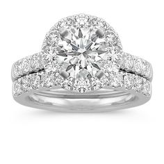 an engagement ring with two halos on top and side stones around the band, set in white gold