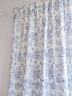 a blue and white floral curtain hanging on a wall