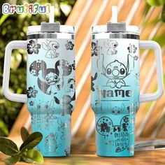 two travel mugs sitting on top of a table next to each other with cartoon characters