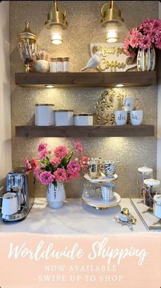 there is a table with flowers and coffee cups on it in front of the shelves