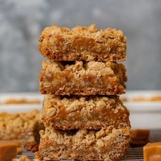 three pieces of granola bar stacked on top of each other in front of a plate