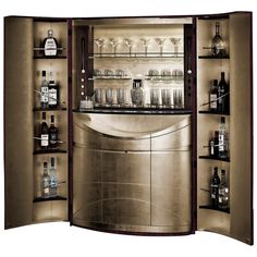 an open cabinet with many bottles and glasses on the shelves in front of it is lit up by dim lighting