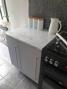 a stove top oven sitting inside of a kitchen next to a wall mounted toaster