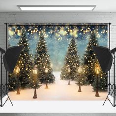 an image of christmas trees in the snow with lights and stars on them behind a backdrop