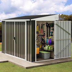 a storage shed with its doors open and tools in it