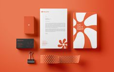 an orange and white stationery set on top of a red surface with a padlock