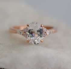 an oval cut diamond ring with three smaller diamonds on top