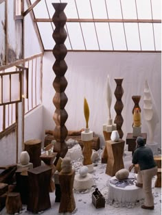 a man standing in front of a room filled with vases