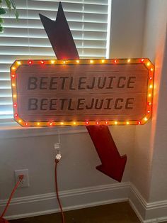 a sign that says beetlejuice and an arrow pointing to the right with lights on it