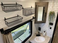 the bathroom is decorated in black and white with baskets on the wall above the sink