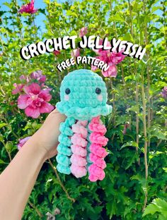 a crocheted jellyfish with pink and blue flowers in the background