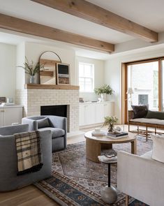 a living room filled with furniture and a fire place in front of a large window