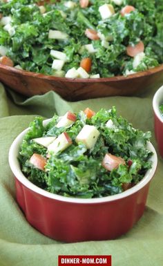 two bowls filled with salad on top of a green cloth