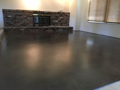 an empty living room with a fireplace in the center and no one around it on the floor