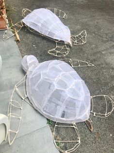 two plastic turtle sculptures sitting on the ground