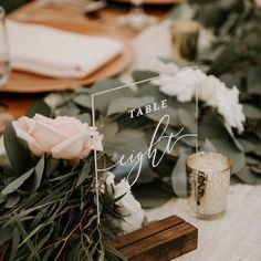 the table is set with flowers and greenery for an elegant touch to the place setting