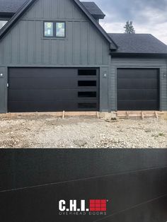 two garages are being built in front of a gray house with black roofing